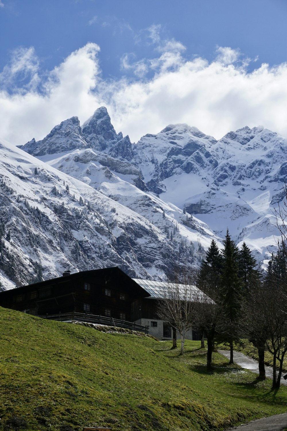 uma montanha coberta de neve com um celeiro em primeiro plano