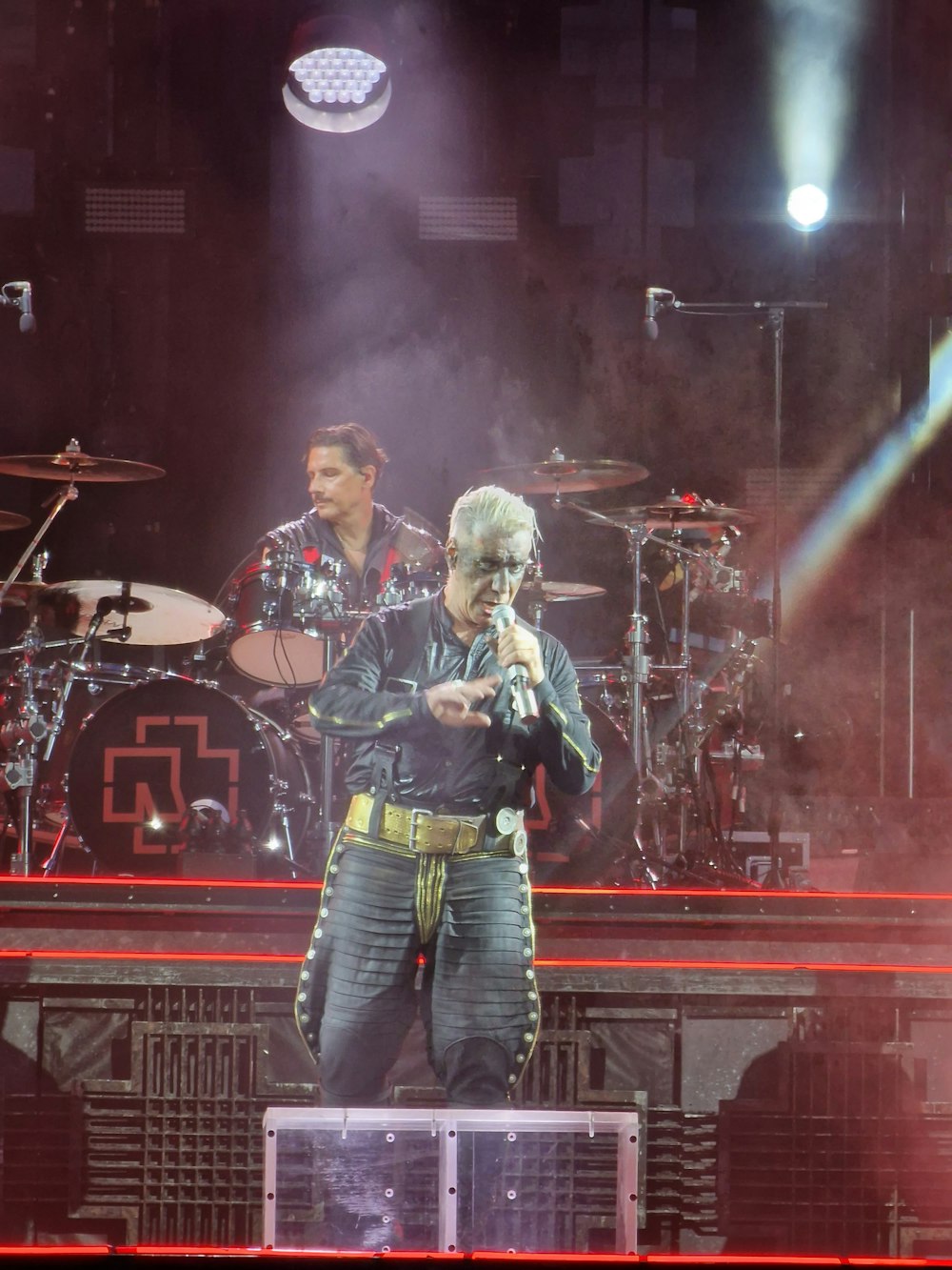 a man standing on top of a stage holding a microphone