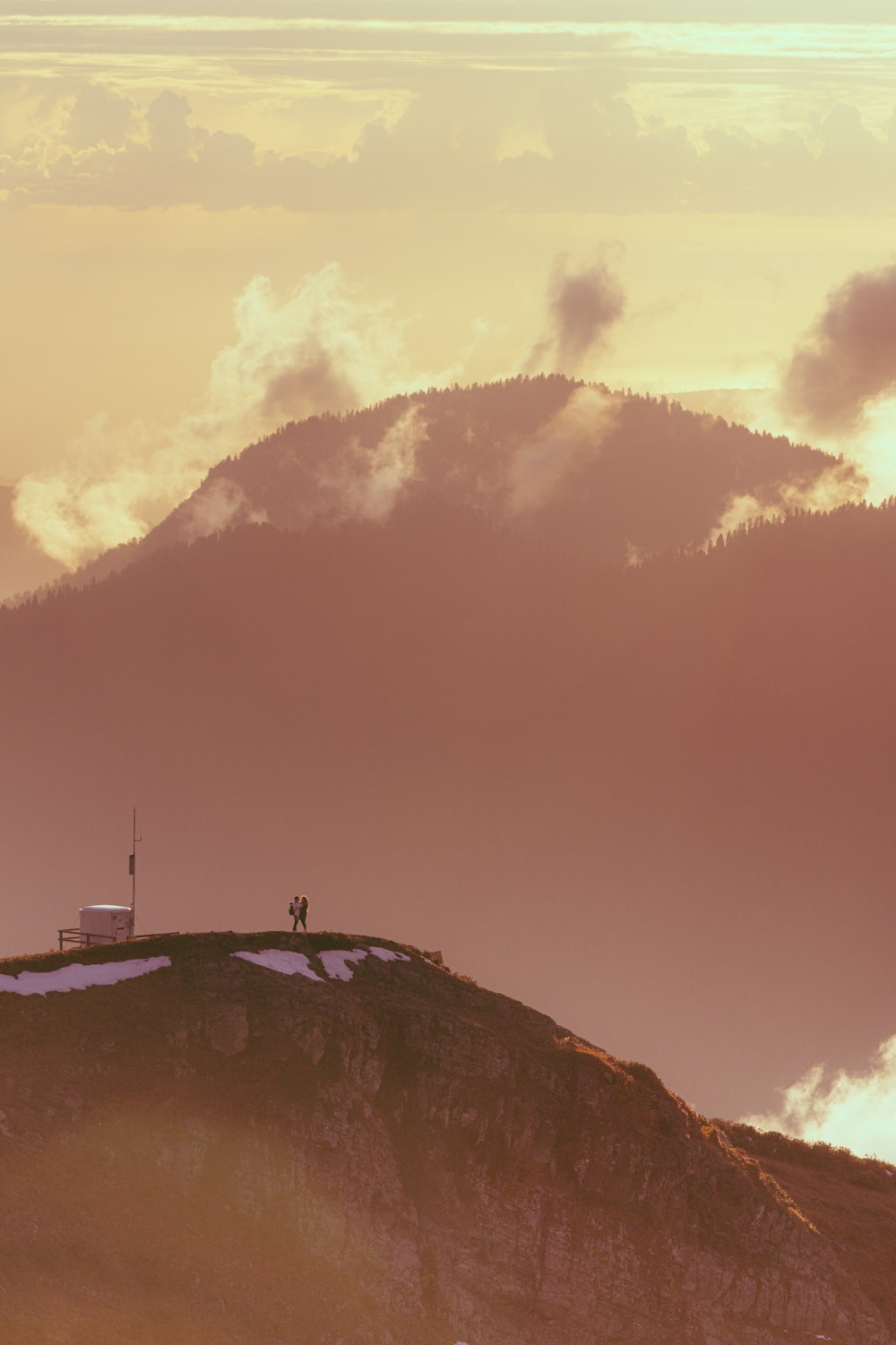 a couple of people standing on top of a mountain