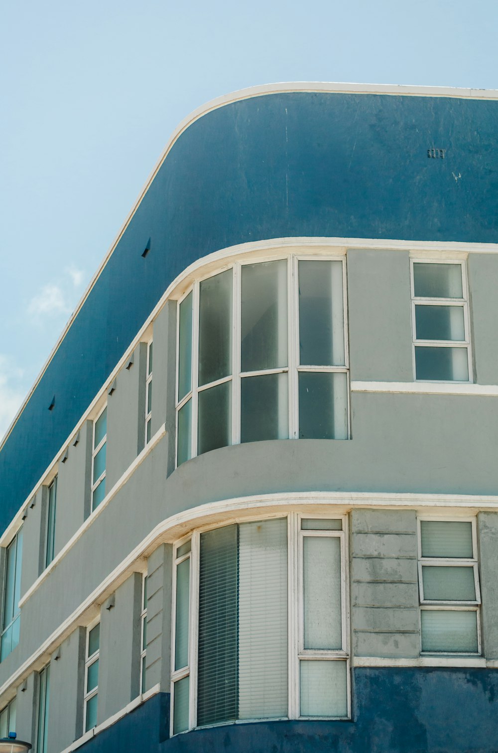 窓とシャッターのある青と白の建物