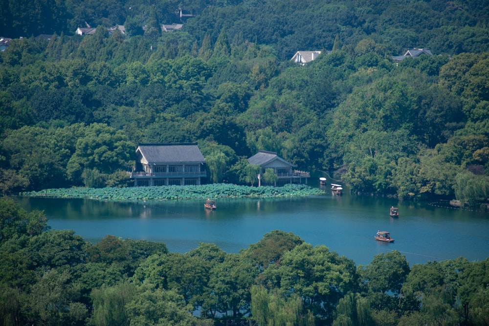 a lake surrounded by lush green trees and houses