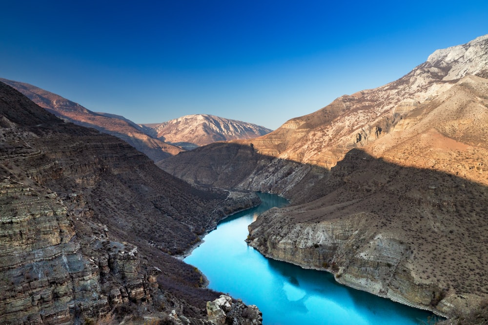 a blue lake surrounded by mountains in the desert