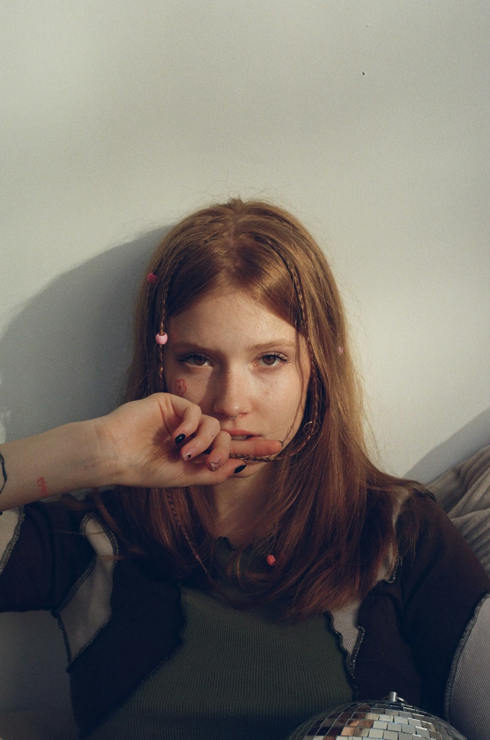 a woman sitting on a couch with her hand on her mouth