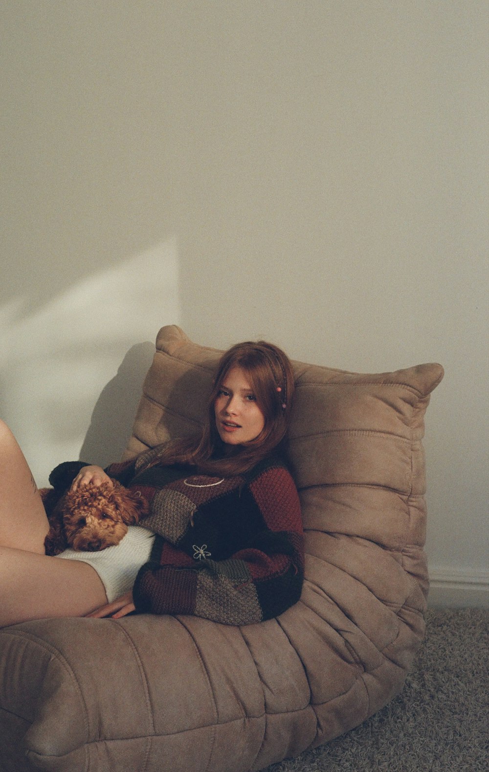 a woman sitting on a bean bag chair holding a teddy bear