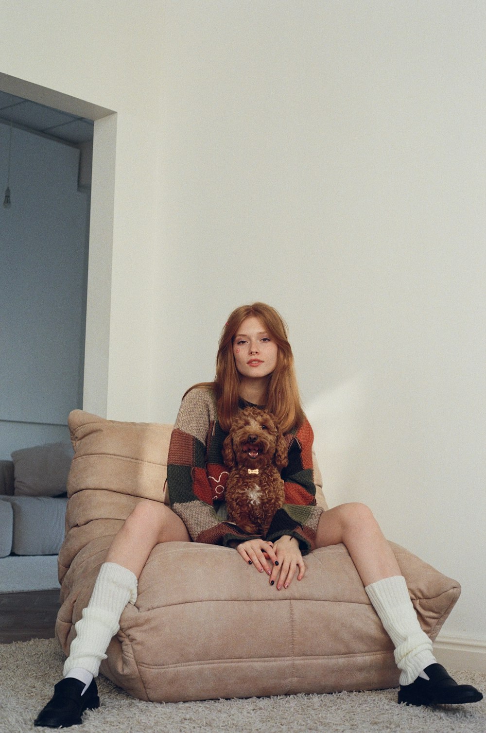 a woman sitting on a couch holding a dog