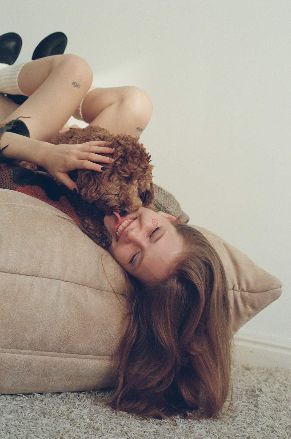 a woman laying on a pillow with a teddy bear
