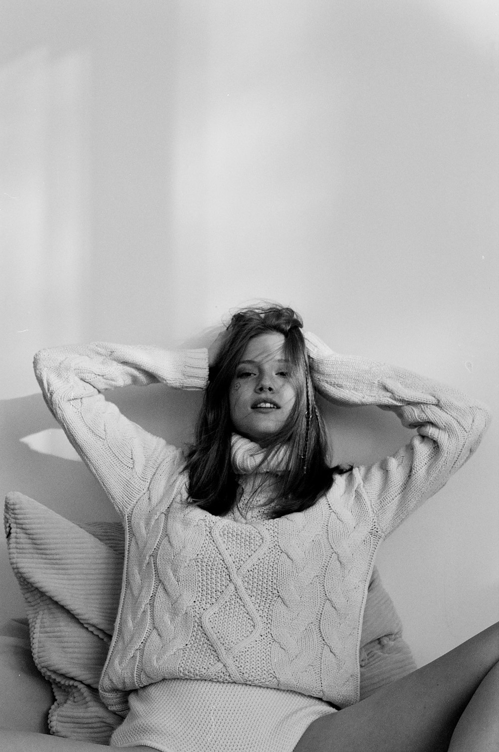 a black and white photo of a woman sitting on a couch