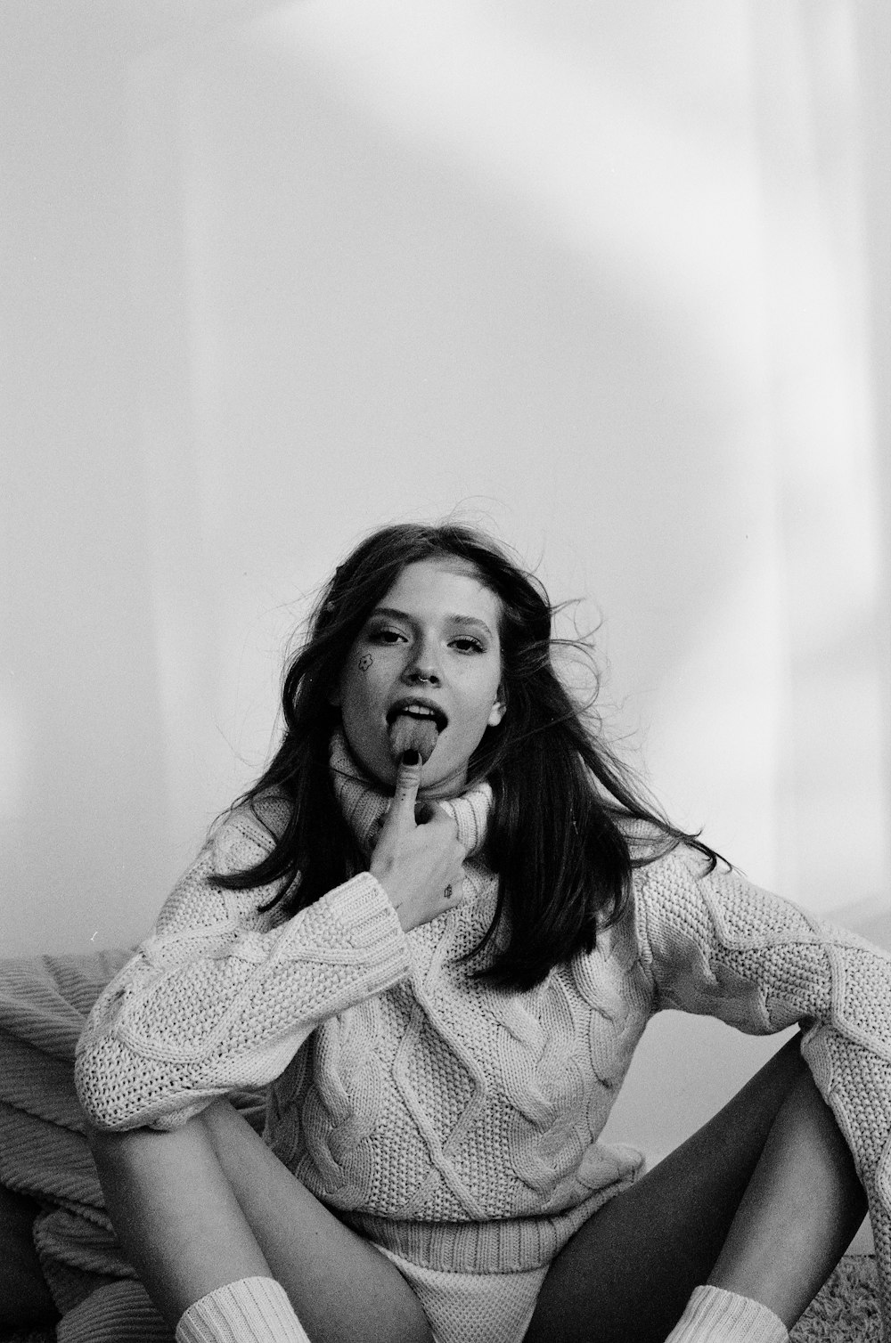 a woman sitting on a bed brushing her teeth