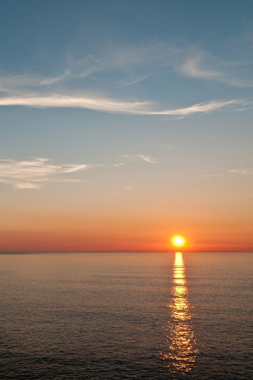 the sun is setting over the ocean on a clear day