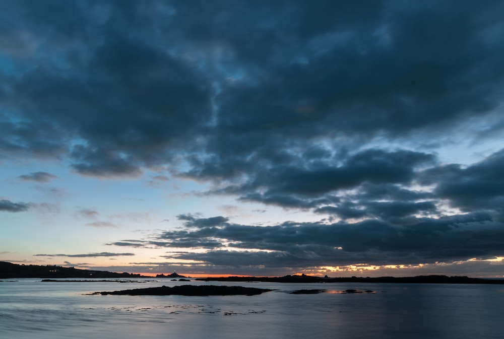 a body of water under a cloudy sky