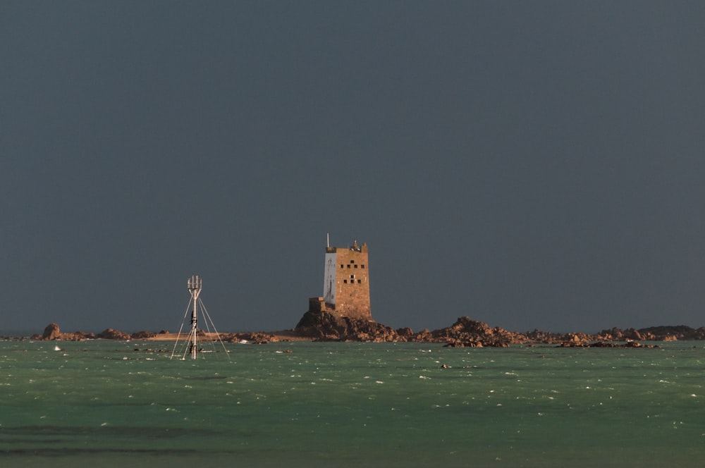 a lighthouse on a small island in the middle of the ocean