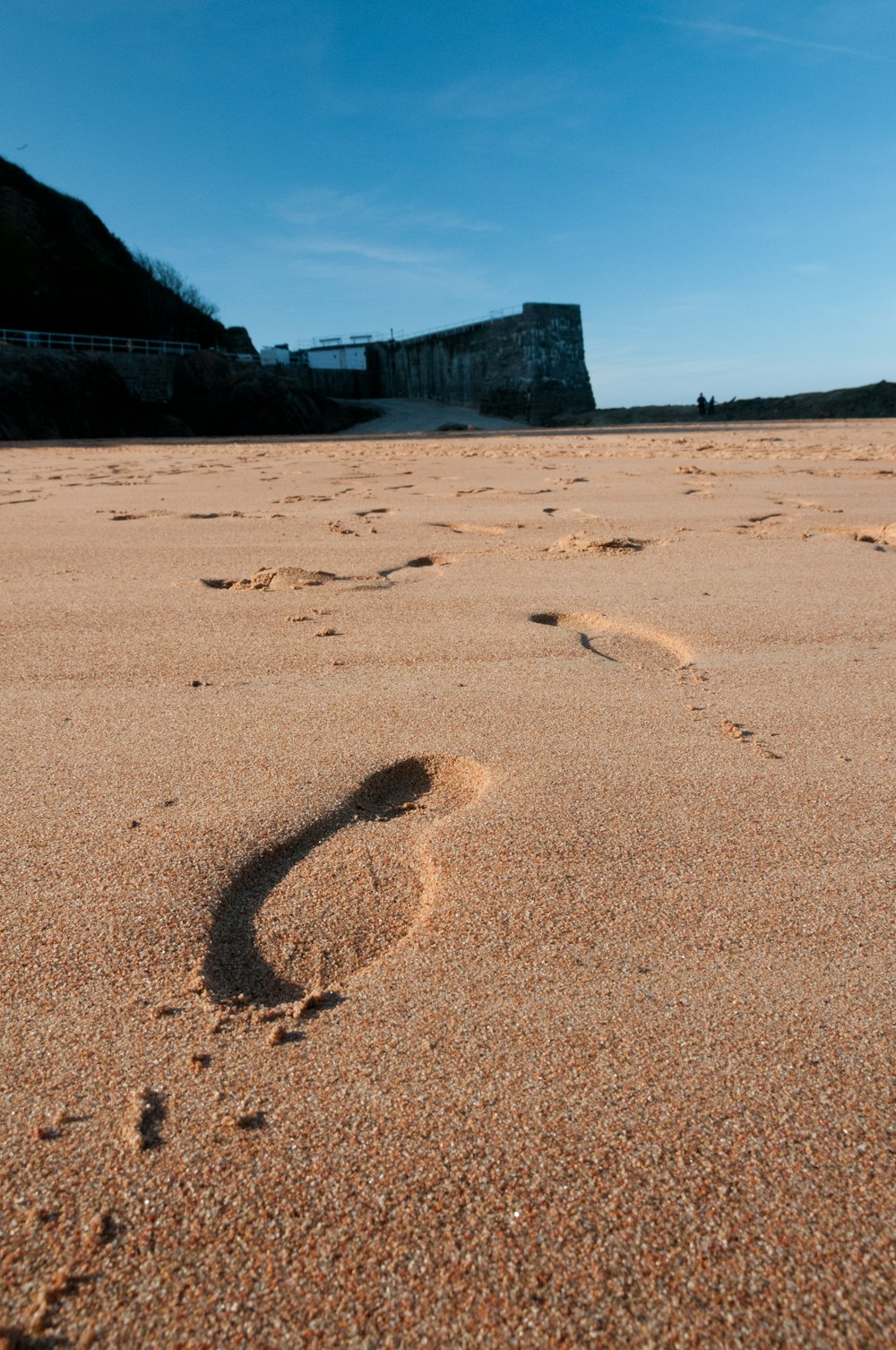 a person's footprints in the sand on a beach