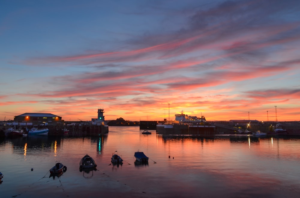 a sunset over a body of water with boats in it