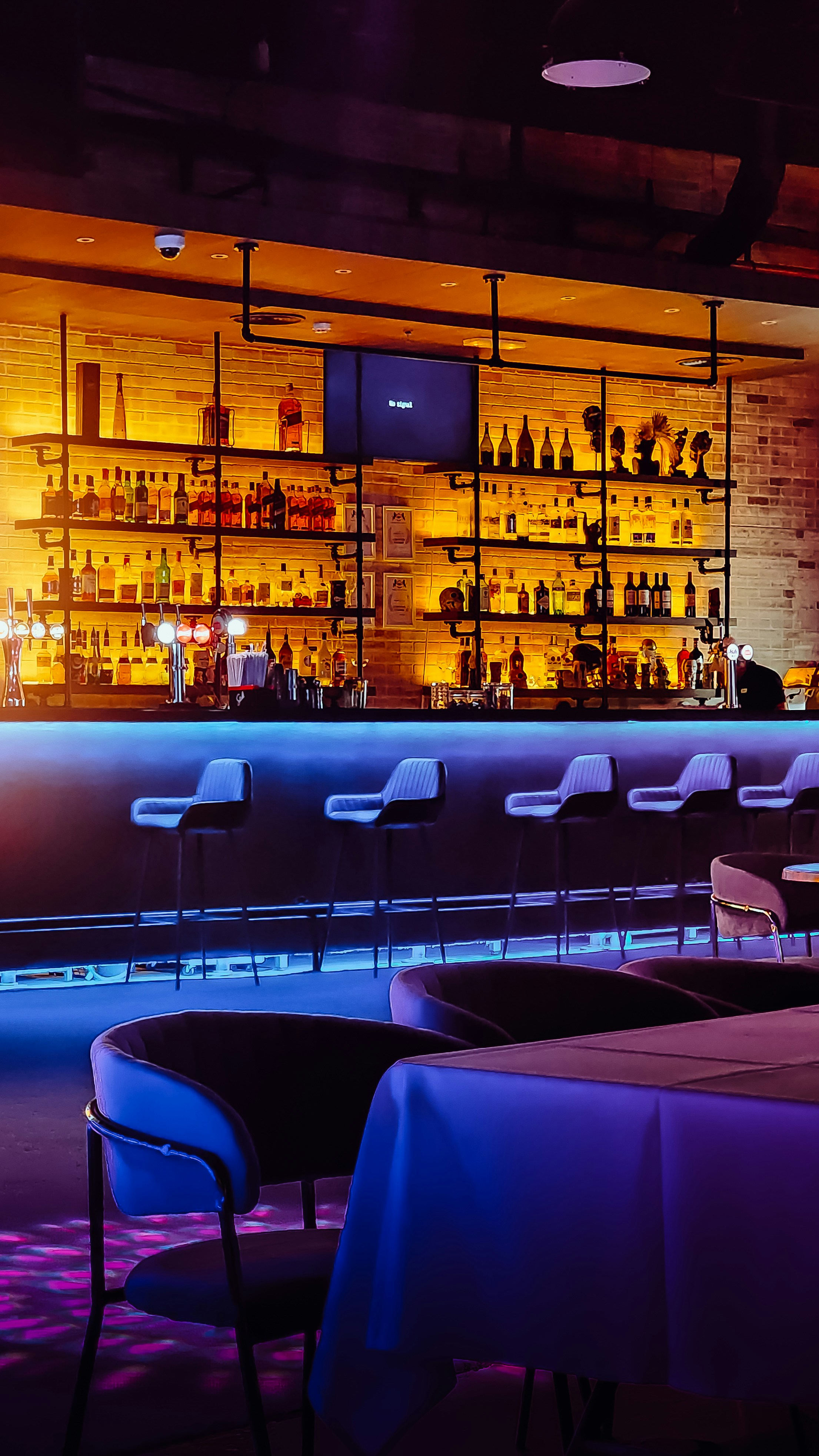 eine schwach beleuchtete Bar mit Stühlen und Tischen