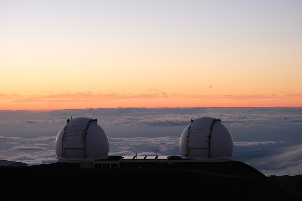 um par de telescópios sentados no topo de uma montanha
