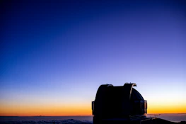 A peaceful observatory dome silhouetted against a colorful twilight sky.