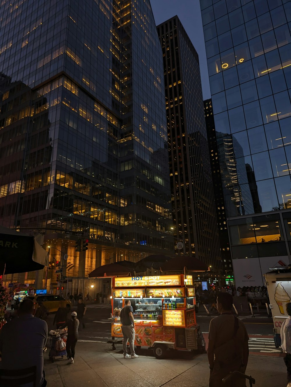 a group of people standing around a food cart