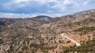 A panoramic view of the Silk Road caravan route winding through rugged mountains.