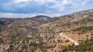 A panoramic view of the Silk Road caravan route winding through rugged mountains.