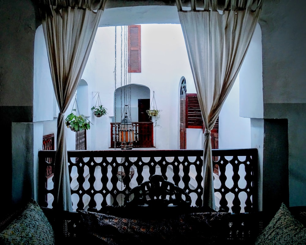 a balcony with a bench and a potted plant