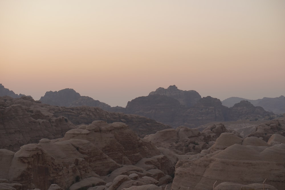 a desert landscape with rocks and mountains in the background