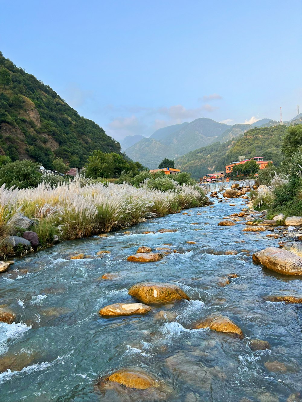 a river running through a lush green hillside