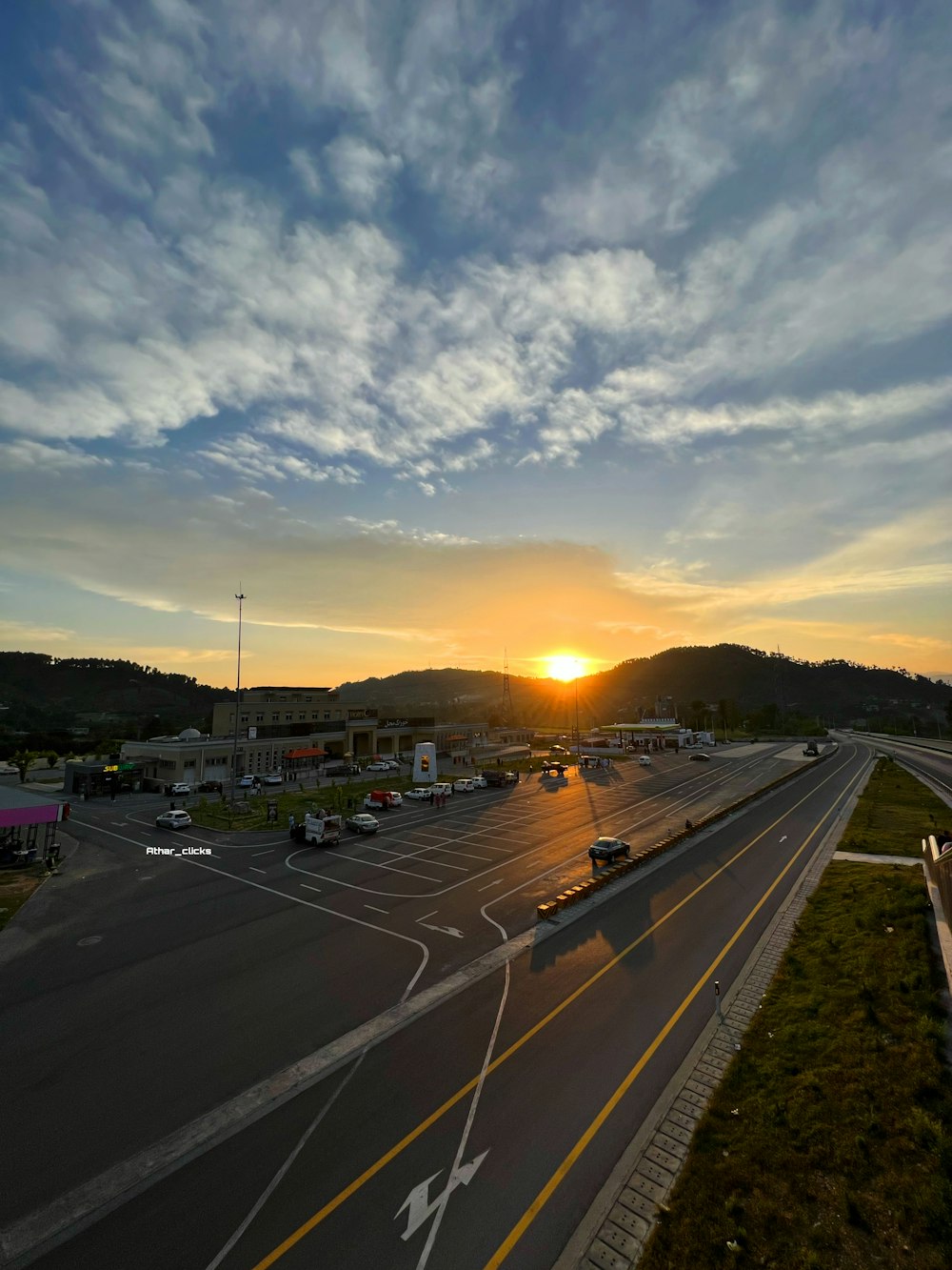 the sun is setting over a parking lot