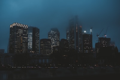 Modern city skyline at dusk with illuminated office buildings symbolizing global property.