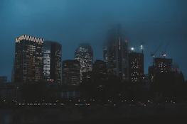 City skyline at dusk with glowing office buildings symbolizing global business connections.