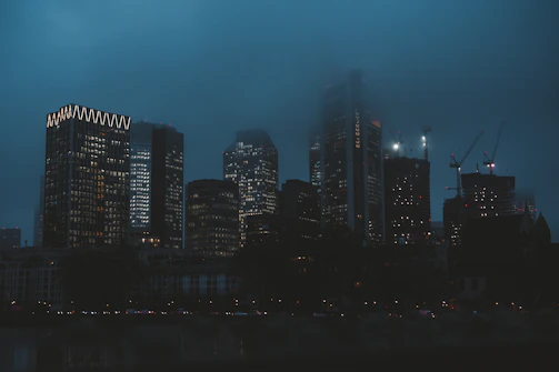 City skyline with glowing office windows at dusk symbolizing economic growth.