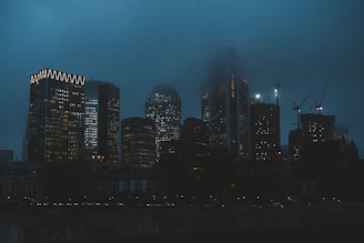 A sleek city skyline at dusk with illuminated office towers symbolizing stability and growth.