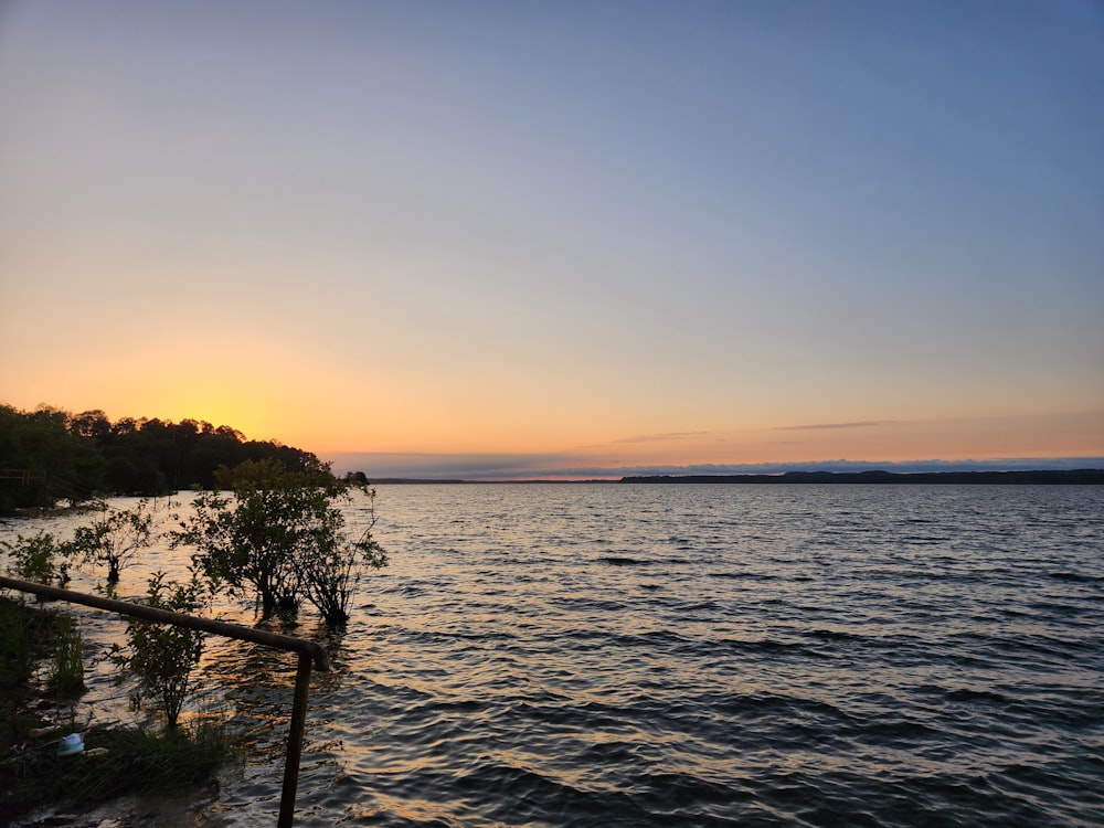 a body of water with a sunset in the background