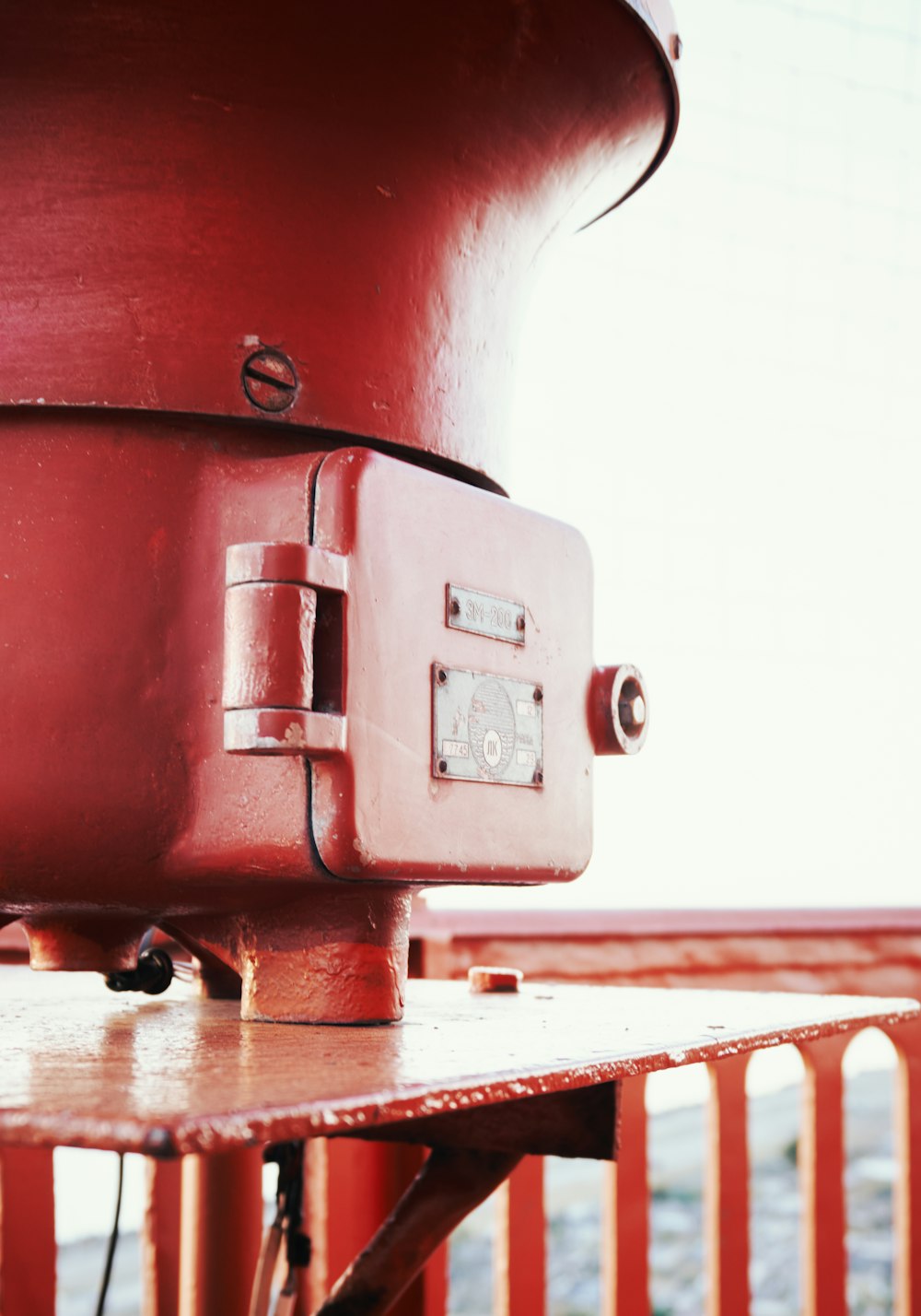 a red metal object sitting on top of a wooden table