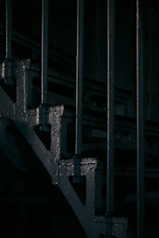 Close-up of a sleek stainless steel single-stringer staircase with industrial lighting.