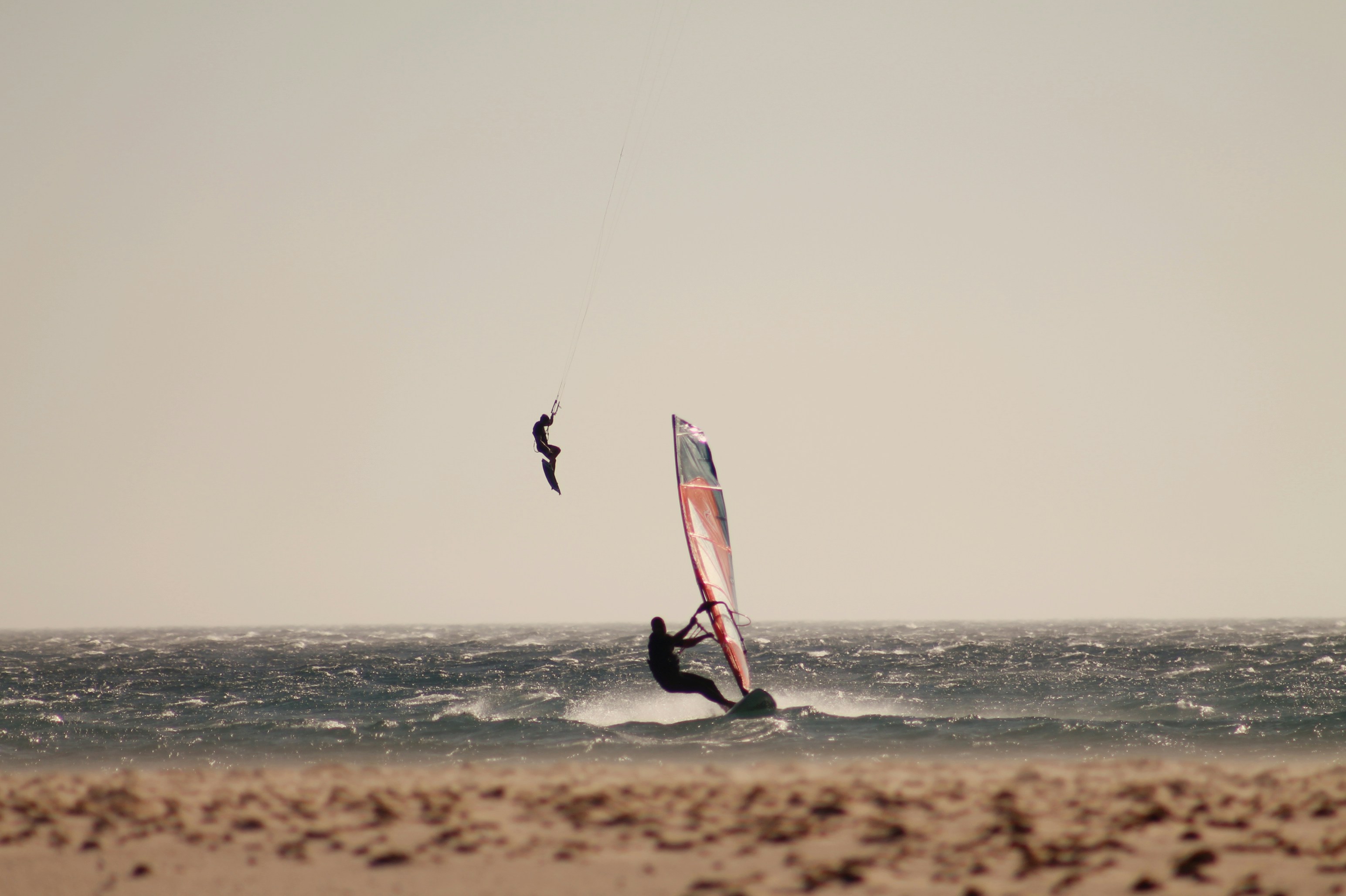 a person windsurfing in the ocean on a sunny day