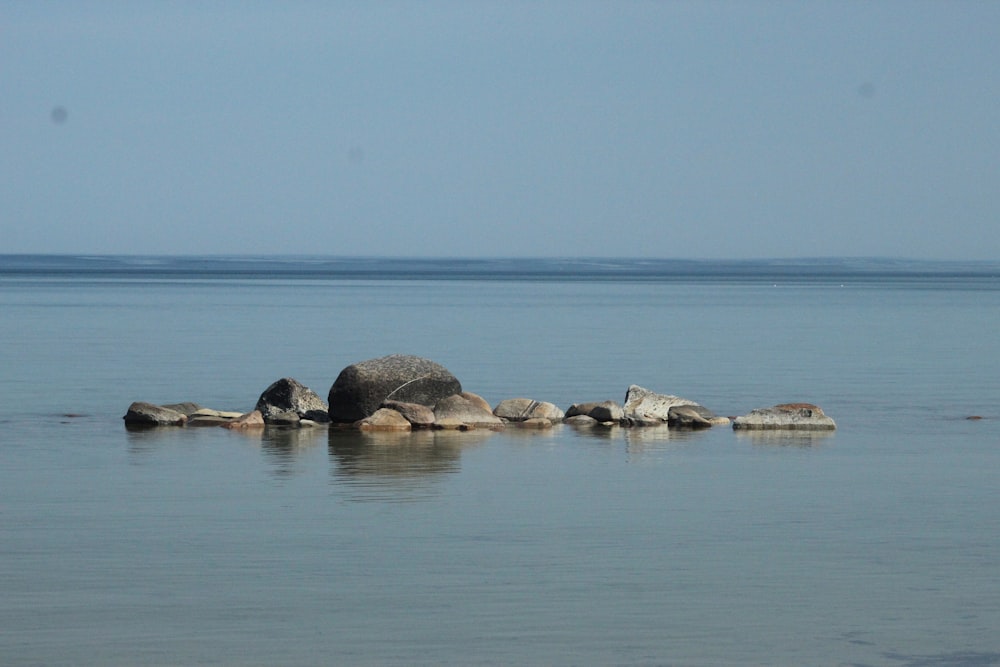 a group of rocks sitting in the middle of a body of water