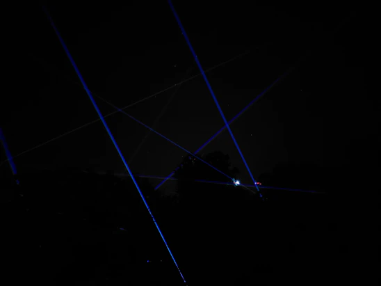 A sleek OVR-Guard device emitting a focused laser beam against a twilight sky backdrop.