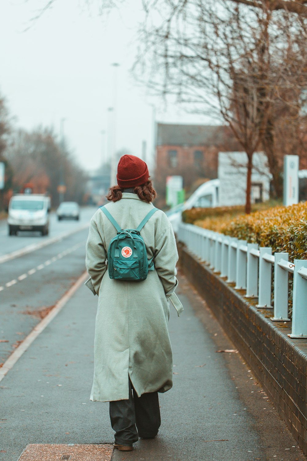 a woman walking down a street with a backpack on her back