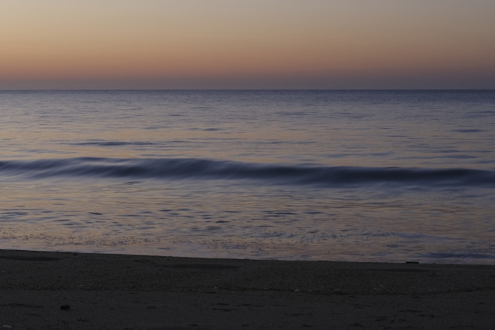 a person standing on a beach next to the ocean