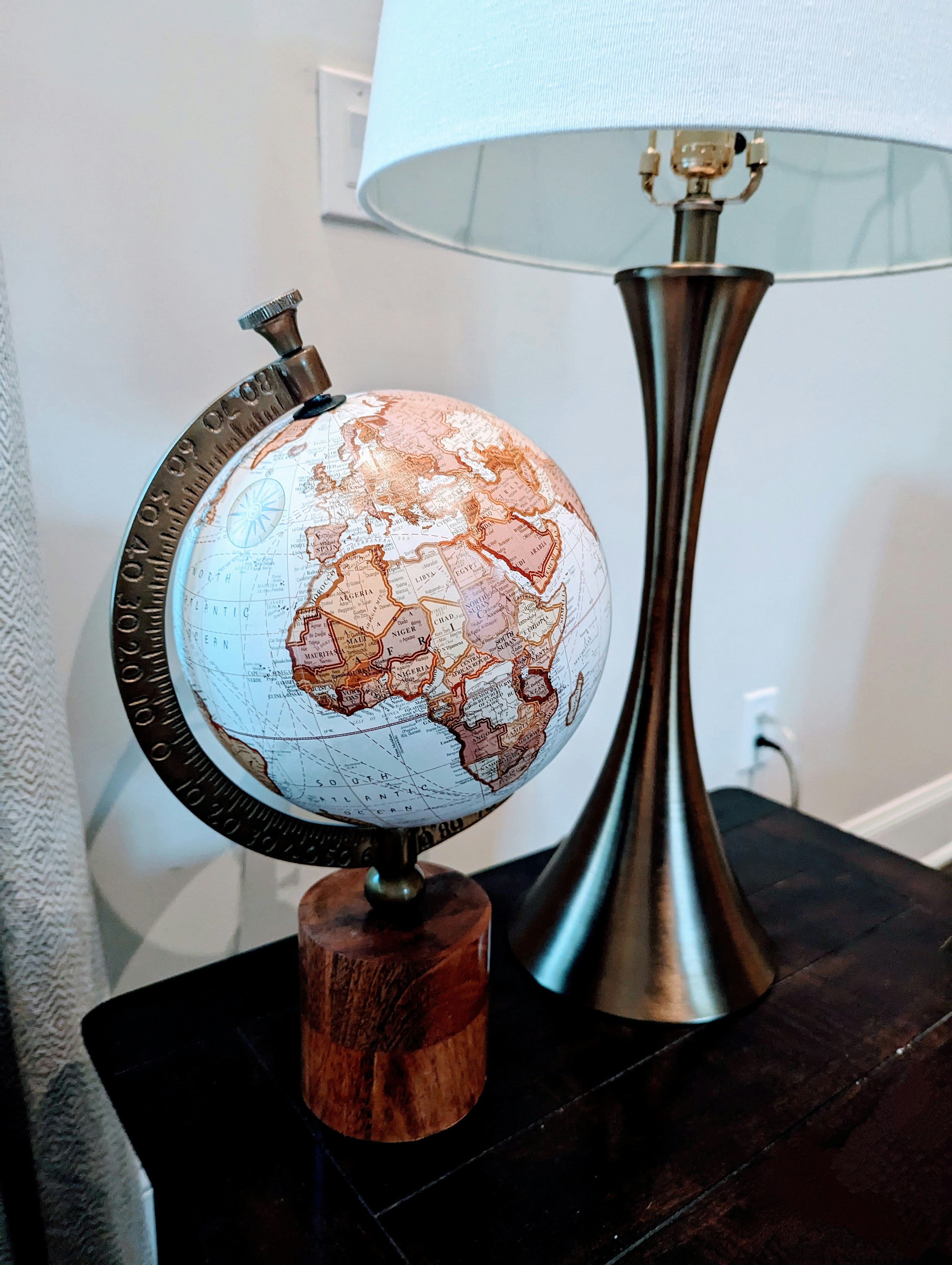 a globe sitting on top of a table next to a lamp