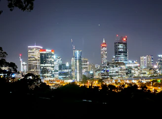 Modern city skyline at night with illuminated buildings powered by clean energy.