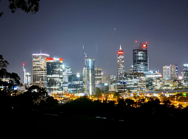 Modern city skyline at night with illuminated buildings powered by clean energy.