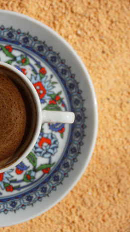 Close-up of a colorful plate featuring pizza, momos, and a cup of steaming coffee.