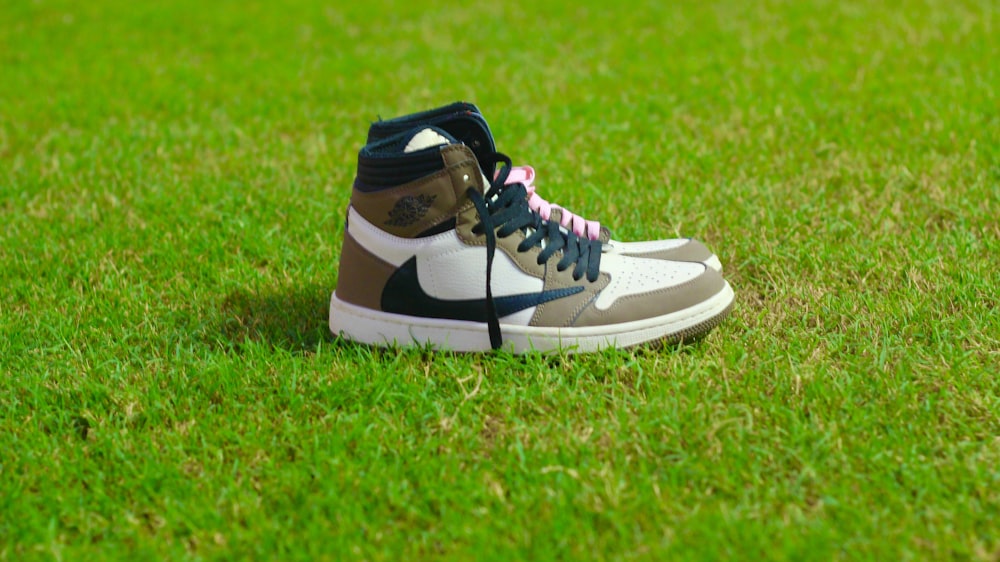 a pair of sneakers sitting on top of a lush green field