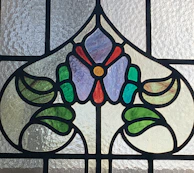 Elegant stained glass door panel featuring warm amber and red tones with floral motifs.