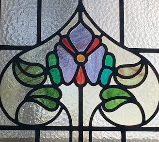 Elegant stained glass door panel featuring warm amber and red tones with floral motifs.
