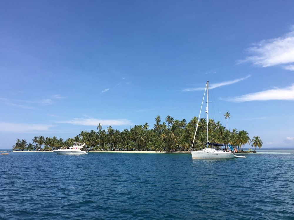 a sailboat in the water near a small island