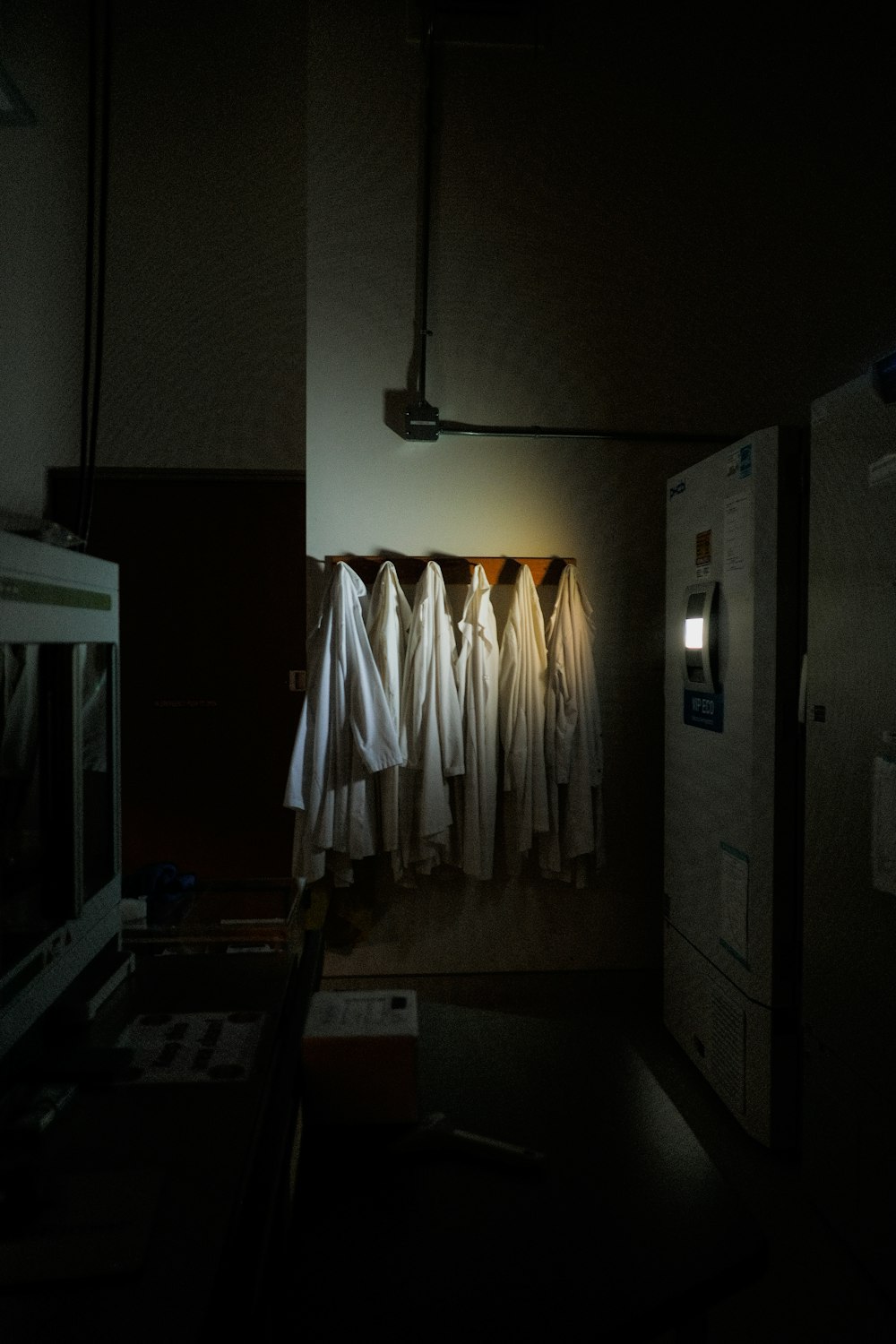a row of white robes hanging on a wall