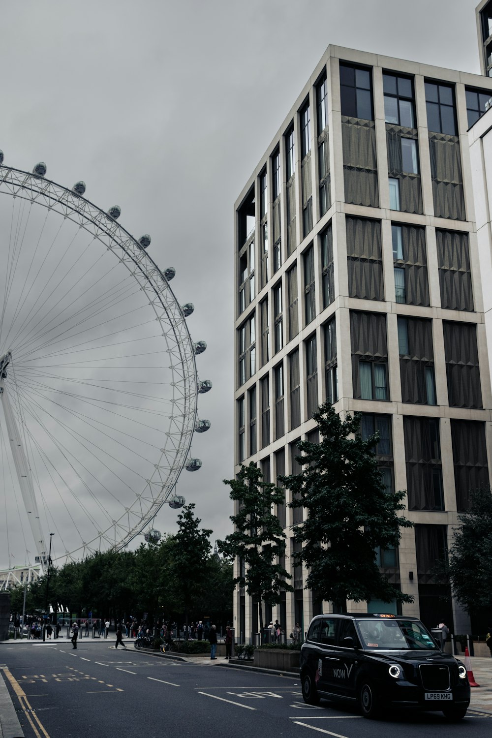 a large ferris wheel sitting next to a tall building