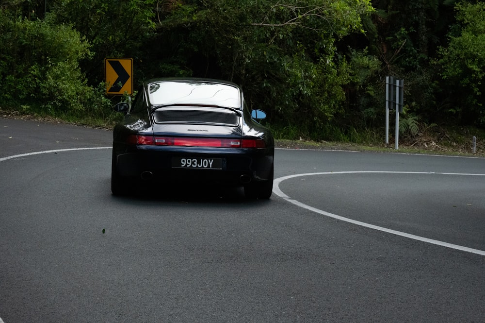 a black sports car driving down a curvy road